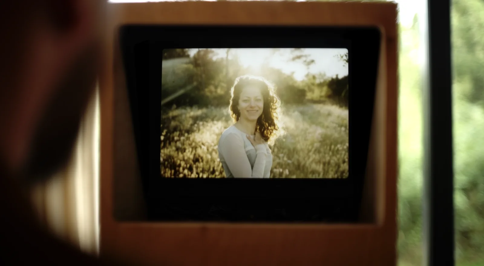 A woman smiling on a small screen built into the camera rig.